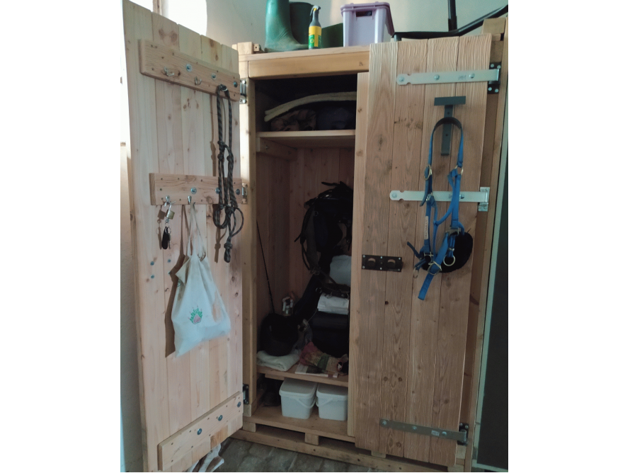 Offener Holzschrank mit Reitzubehör