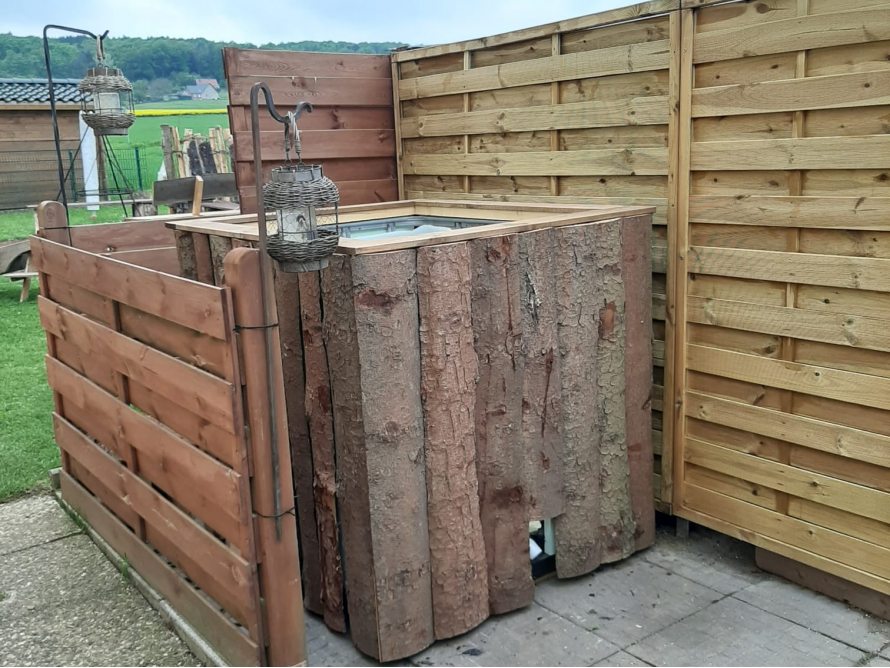 Gartenhaus aus Holz mit Laternen.