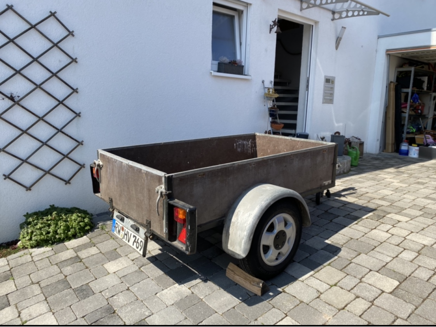 Ein leerer Anhänger auf einem gepflasterten Hof.