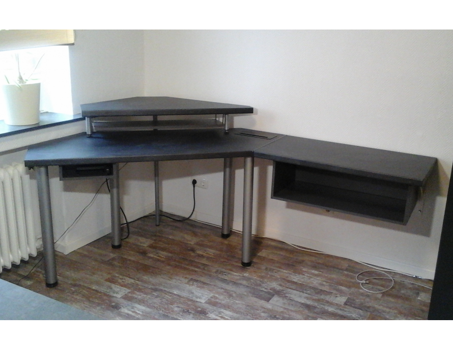 Ein grauer Eck-Computertisch aus Holz.