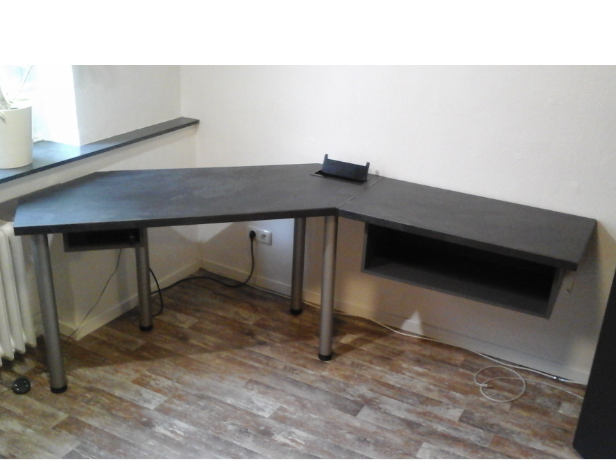 Ein grauer Eck-Computertisch mit silbernen Beinen.