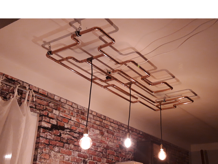 Kupferrohrlampe an einer Ziegelwand