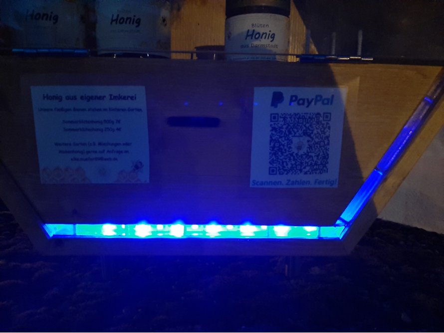 Holzstand mit Honiggläsern und QR-Code