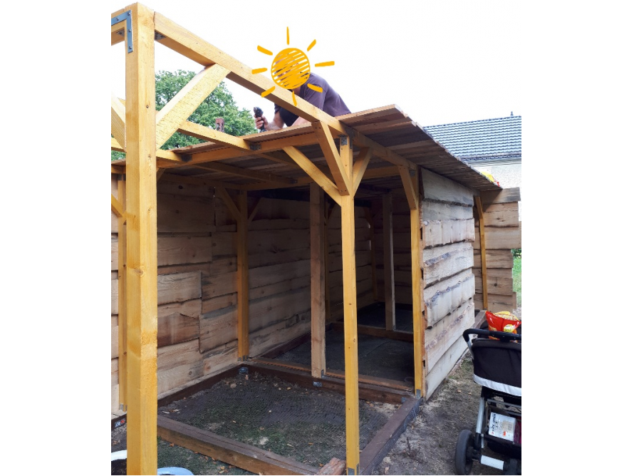 Person baut ein Gartenhaus aus Holz