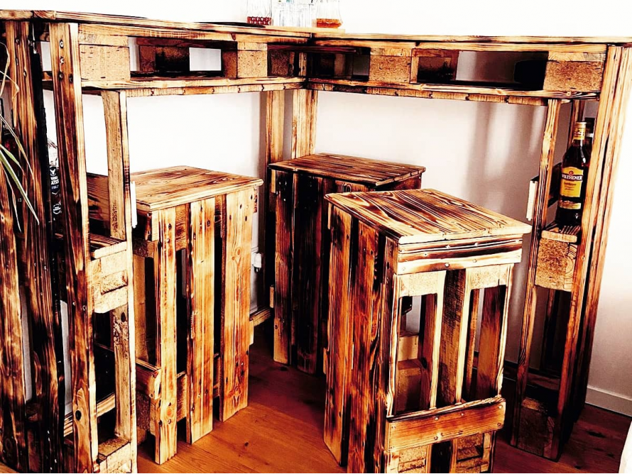 Bar aus Palettenholz mit drei Barhockern
