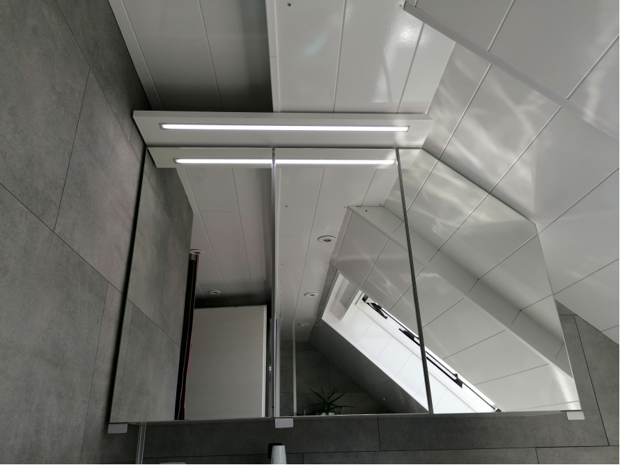 Spiegel in einem Badezimmer mit Dachschräge.