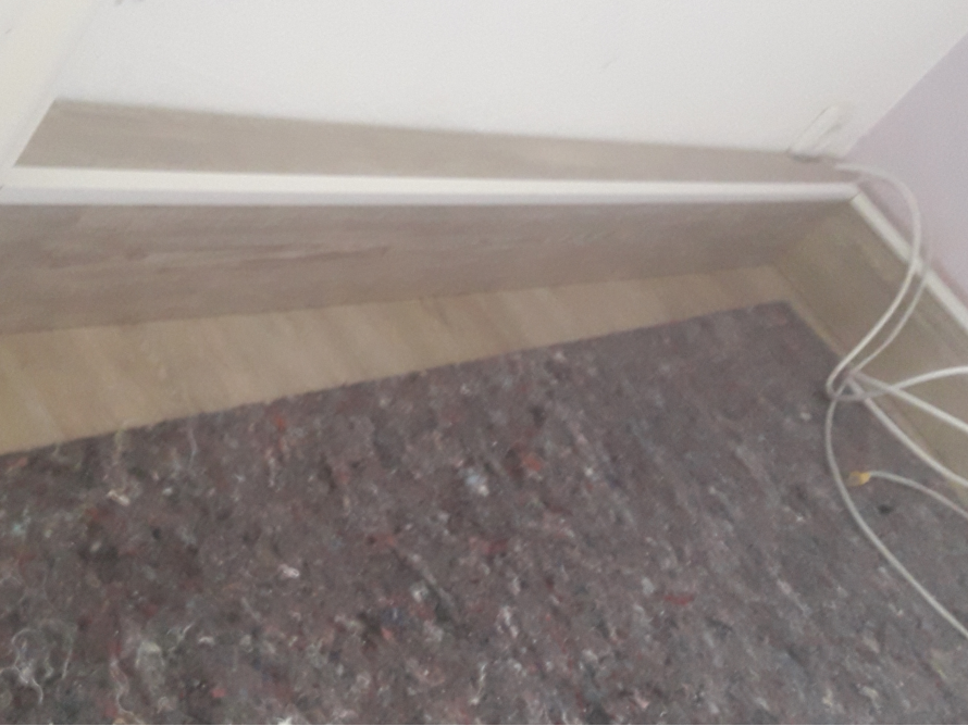 Holzsockel an Wand und Teppich