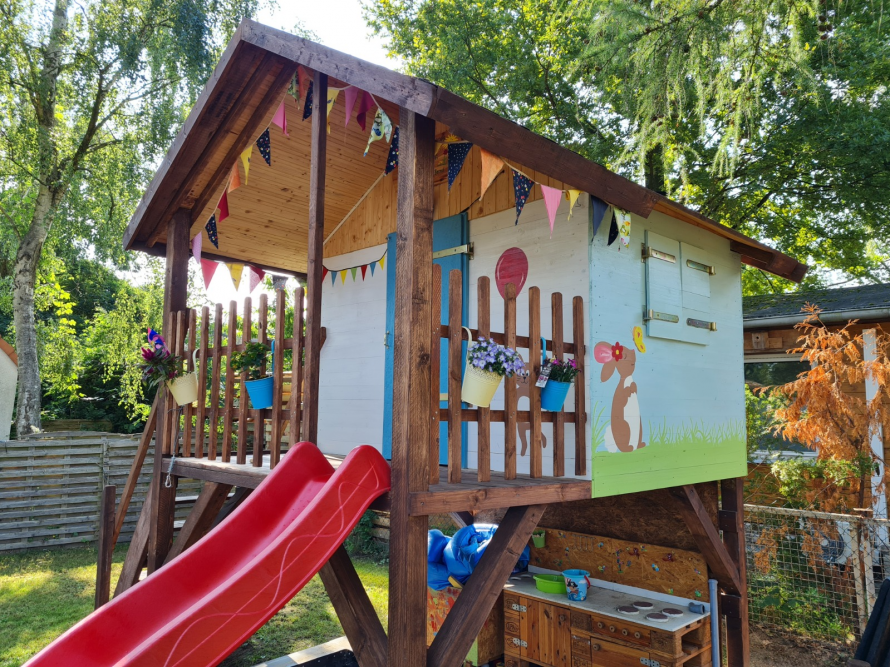 Spielhaus aus Holz mit Rutsche