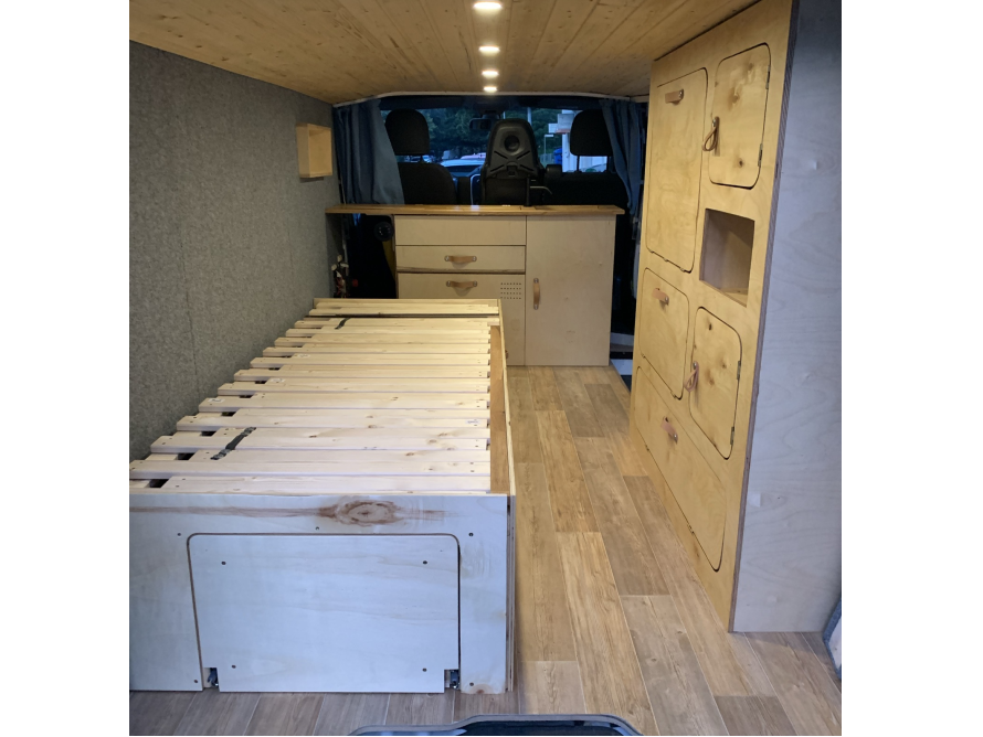 Innenausbau eines Campingbusses mit Bett und Schränken