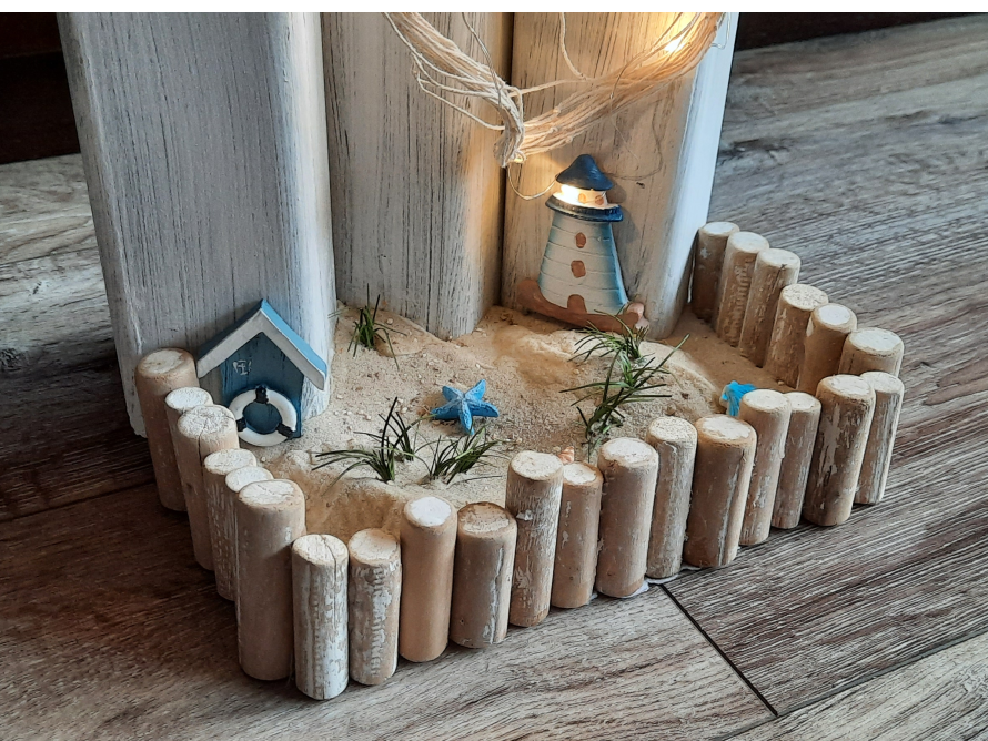 Maritime Dekoration mit Leuchtturm und Strandhütte