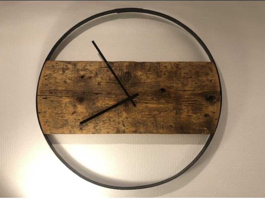 Eine Uhr mit einem Holzzifferblatt in einem Metallrahmen