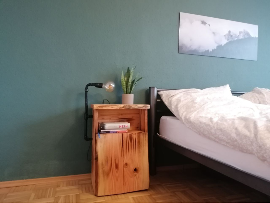 Rustikaler Nachttisch aus Holz mit Lampe