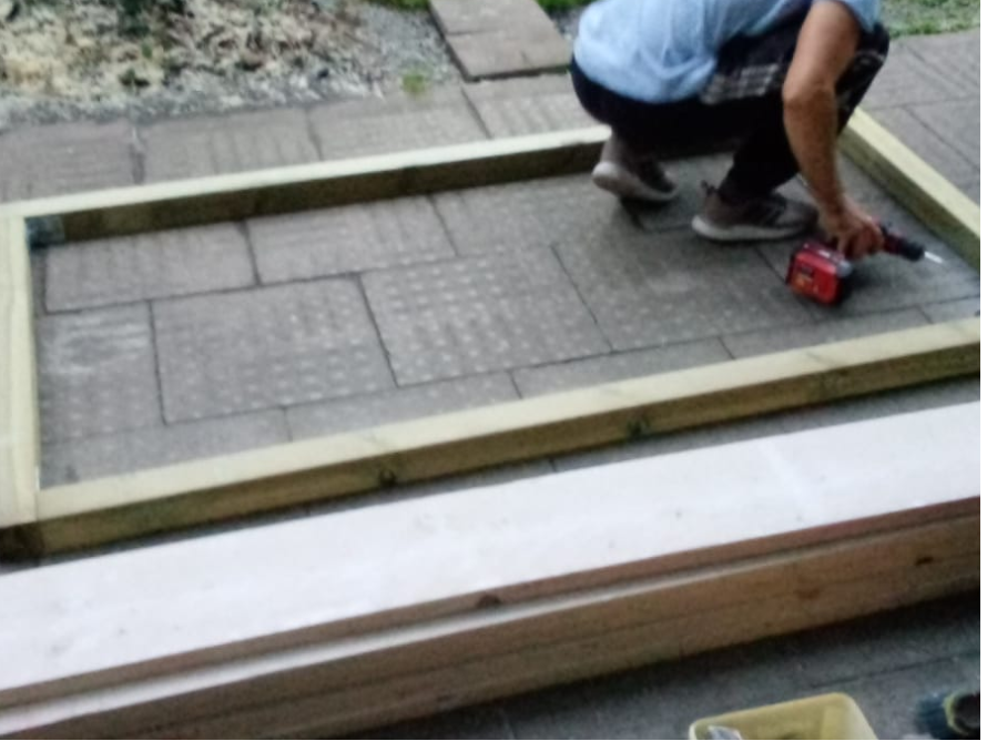 Person baut einen Holzrahmen mit Akkuschrauber