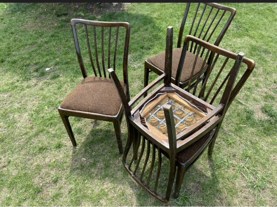 Vier braune Holzstühle auf dem Rasen