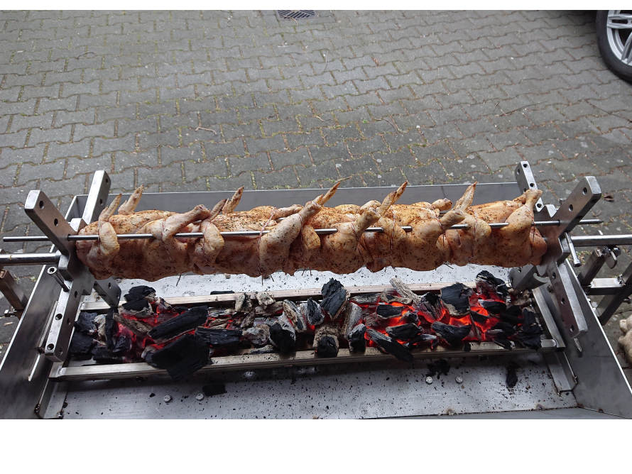 Acht Hähnchen auf einem Grill über Holzkohle