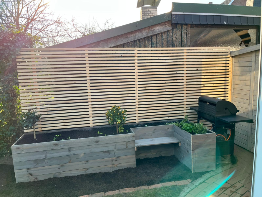 Gartenzaun aus Holz mit Hochbeeten