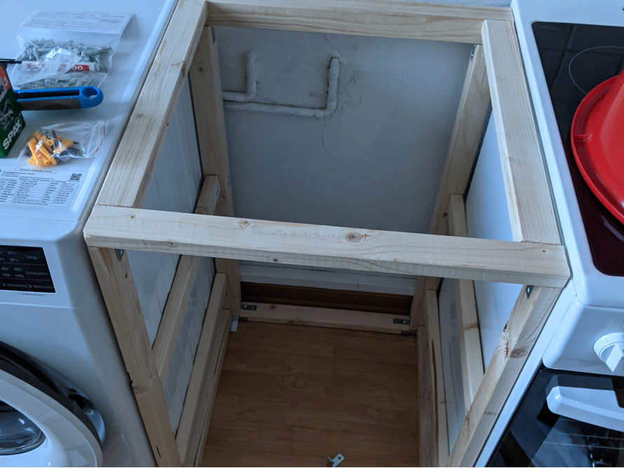 Holzrahmen eines Schranks über einer Waschmaschine