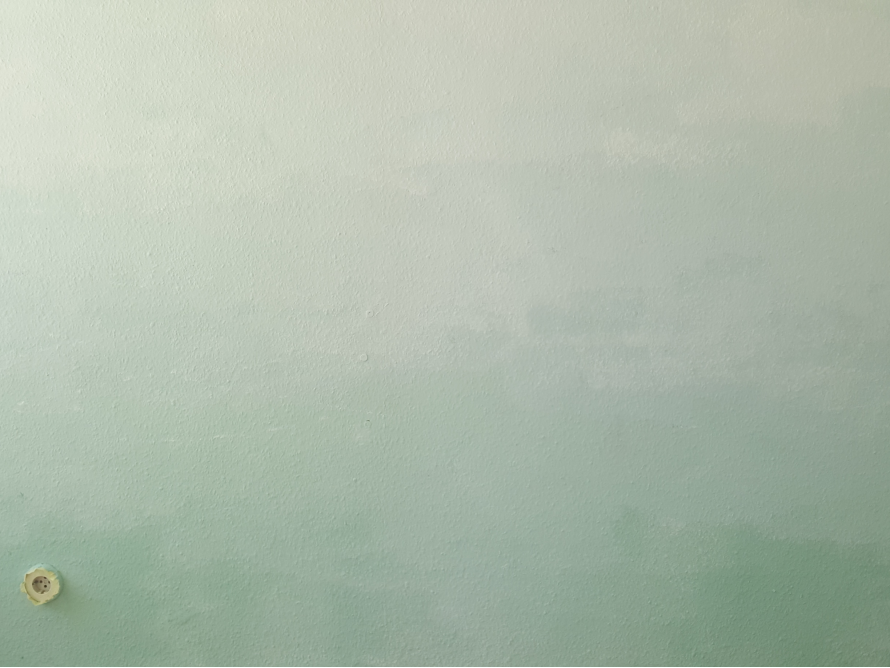 Verwaschen grün gestrichene Wand