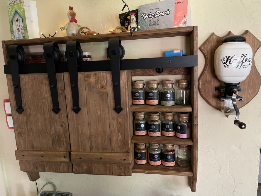 Ein rustikales Gewürzregal mit Schiebetüren aus Holz.