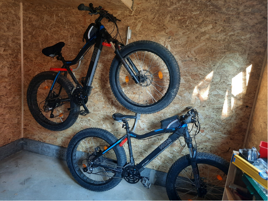 Zwei Fahrräder hängen an einer Wand.