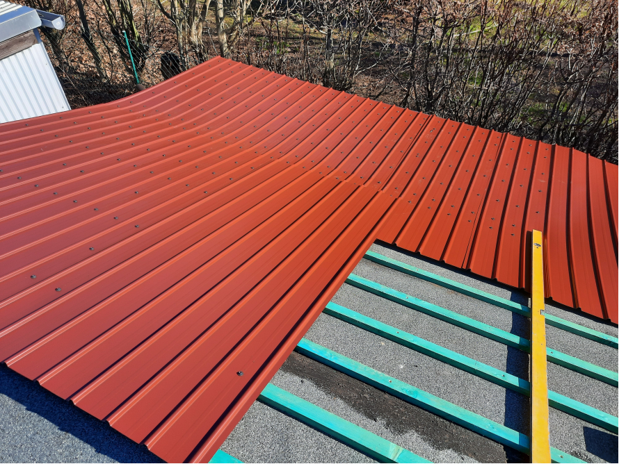 Rote Dachziegel auf einem Holzdachstuhl