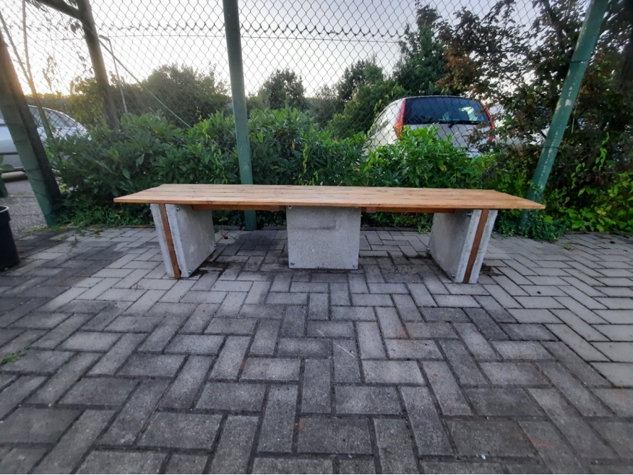 Eine Bank mit Holzbrett und Betonfüßen
