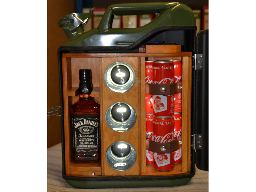 Eine grüne Metallbox mit Holzeinbauten ist geöffnet und zeigt eine Flasche und Dosen im Inneren sowie drei Gläser.