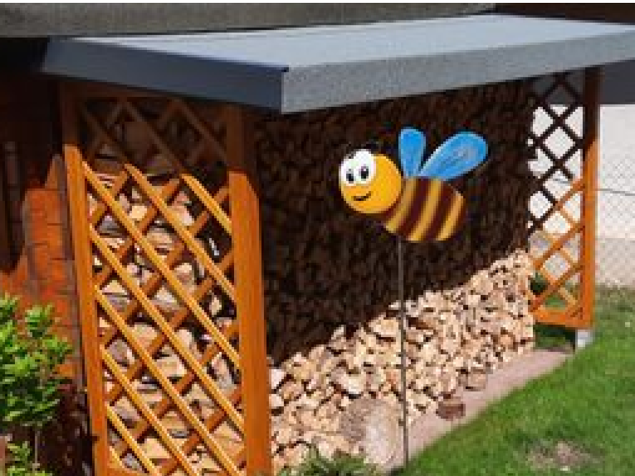 Holzlager für Brennholz mit Biene als Deko