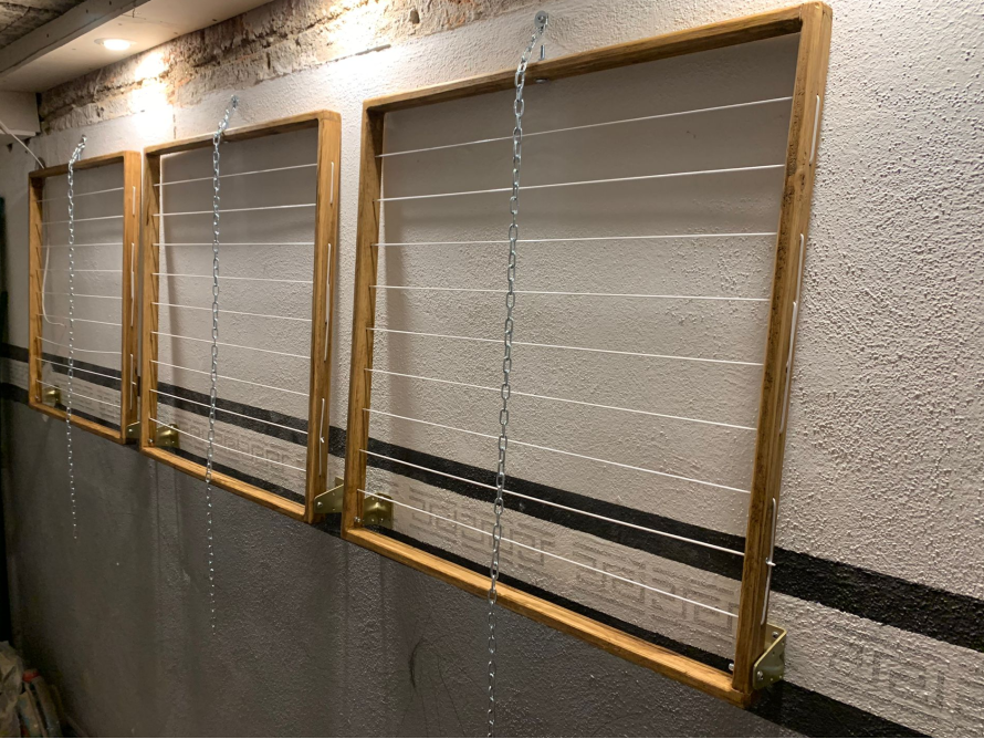 Drei Wäschetrockner aus Holz an einer Wand