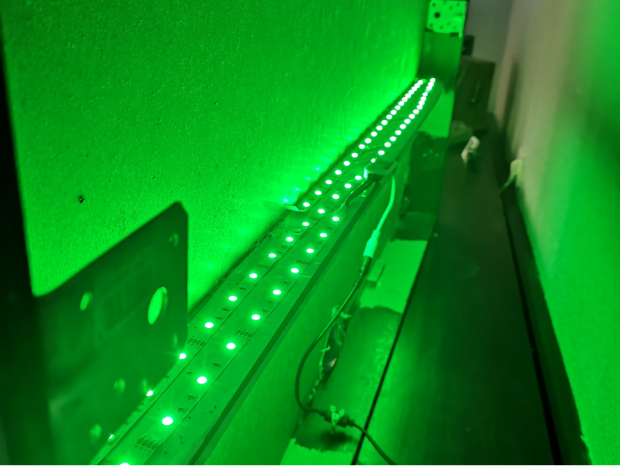 Grüne LED-Leiste leuchtet an einer Wand