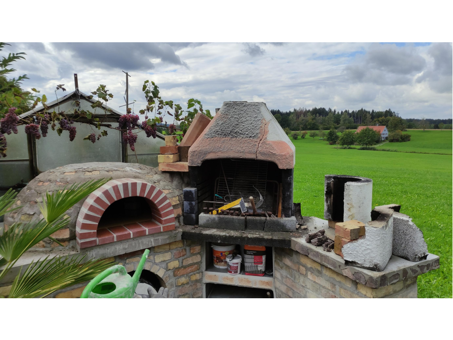 Ein gemauerter Pizzaofen im Garten.