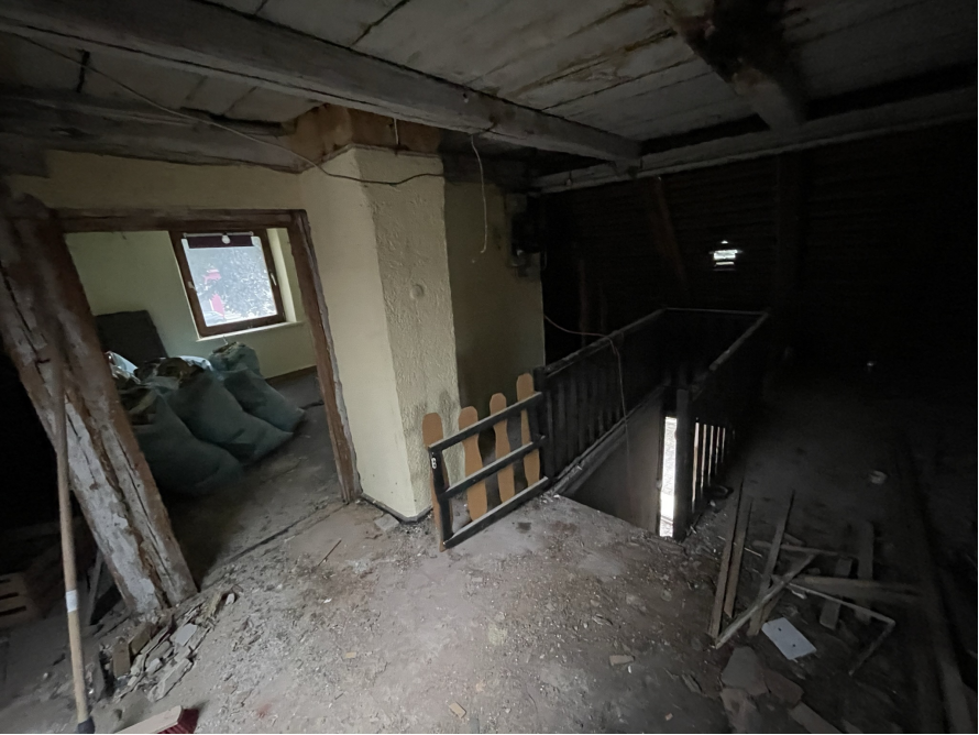 Verlassener Dachboden mit Bauschutt und Müllsäcken