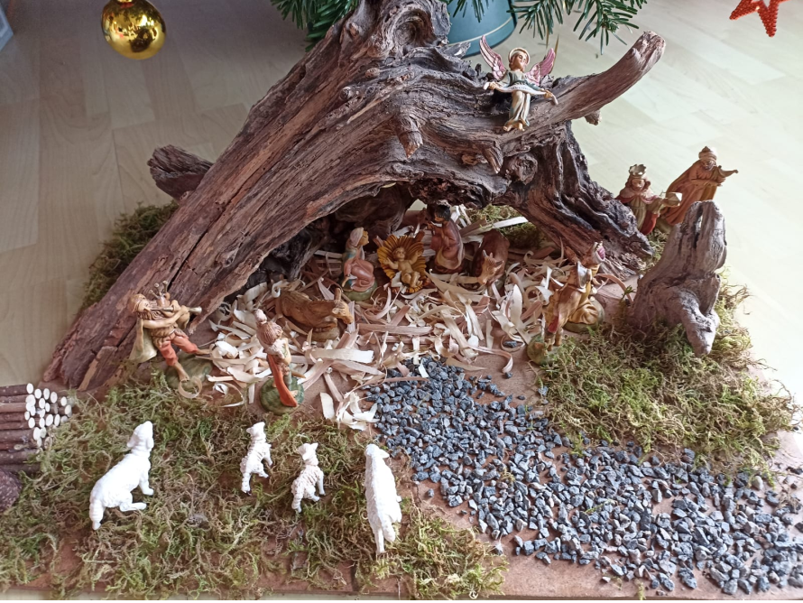 Weihnachtskrippe unter einem Stück Baumrinde