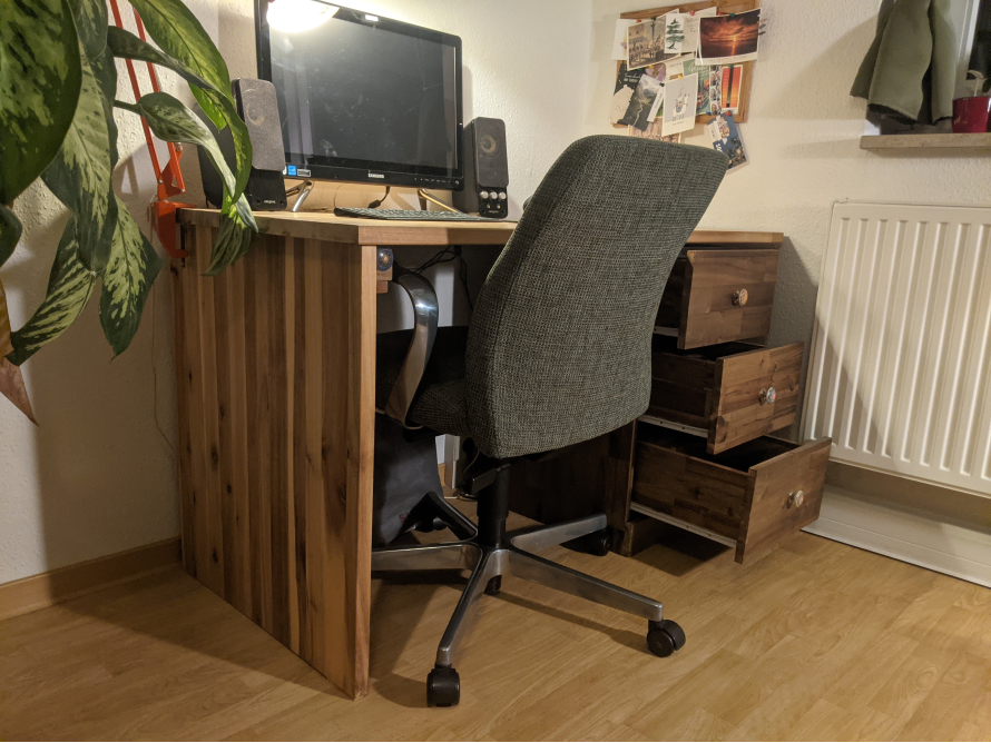 Holzschreibtisch mit Computer und Drehstuhl