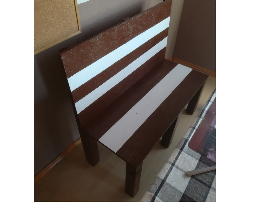 Braune Holzbank mit weißen Streifen