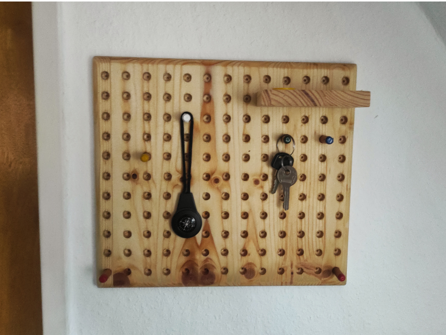 Eine Lochplatte aus Holz an der Wand