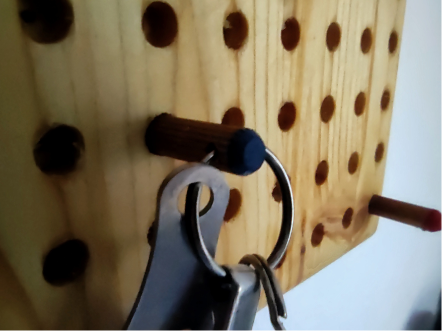 Schlüsselbund an einem Holzbrett mit Löchern