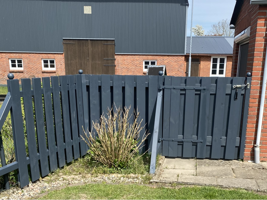 Dunkelgrauer Holzzaun mit Gartentor