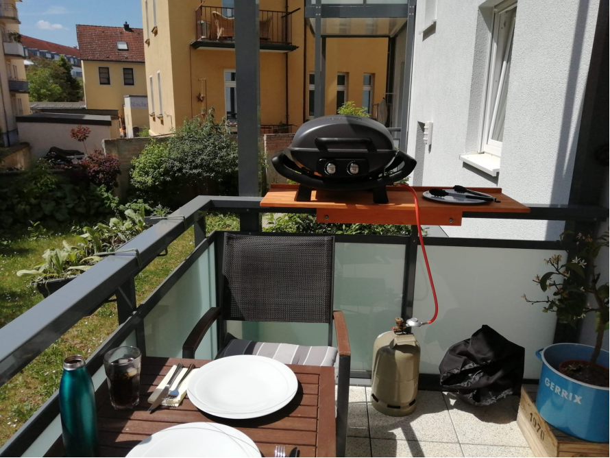 Balkon mit Gasgrill und gedecktem Tisch
