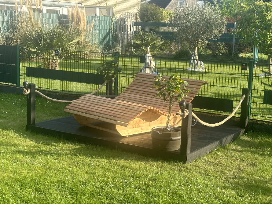 Hölzerne Liege auf Terrasse im Garten