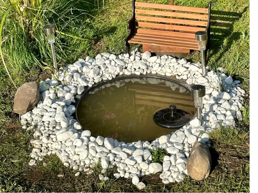Runder Gartenteich mit Springbrunnen und Solarlampen