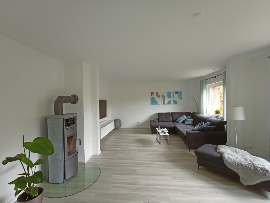 Helles Wohnzimmer mit Kamin und großer Couch