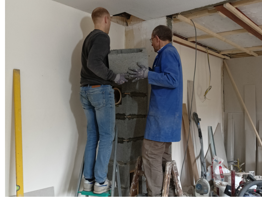 Zwei Personen mauern einen Schornstein