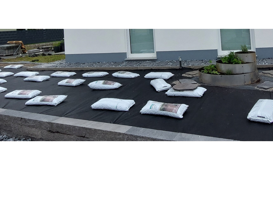 Gartenfläche mit Säcken auf Vlies