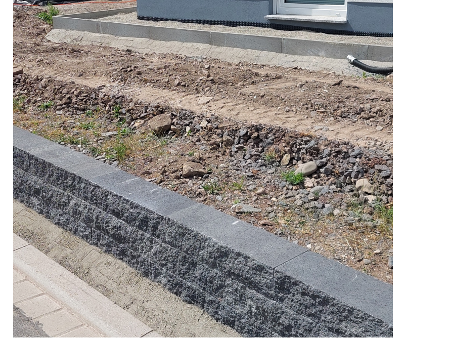 Neuer Bordstein und frisch aufgeschüttete Erde
