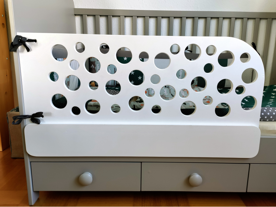 Weißes Babybett mit rundem Gitter