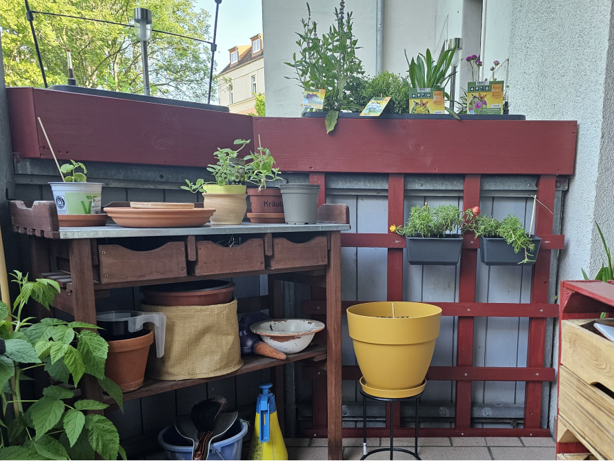 Balkon mit Pflanzen und Gartengeräten