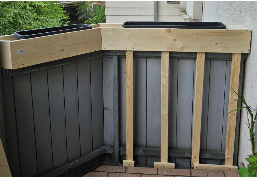 Zwei Blumenkästen auf einem Holzgestell