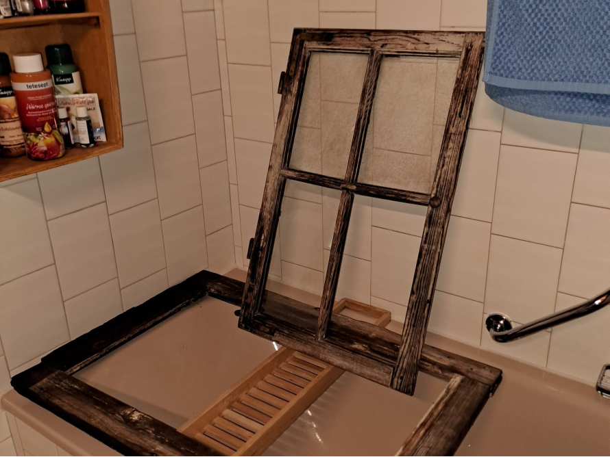 Altes Fenster liegt in Badewanne