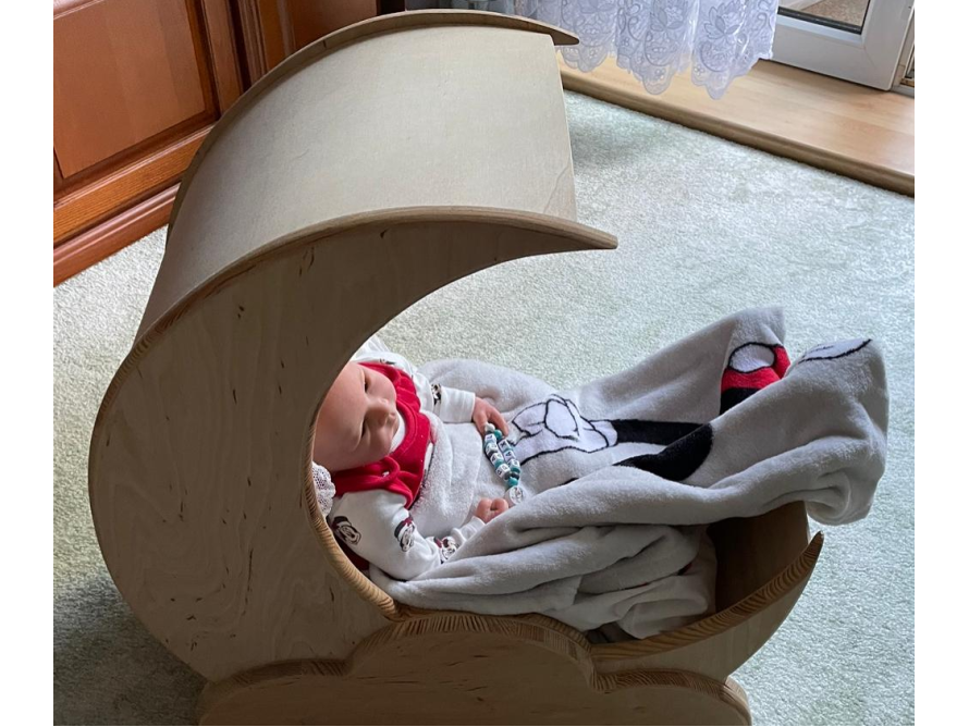 Baby in einem mondförmigen Babybett